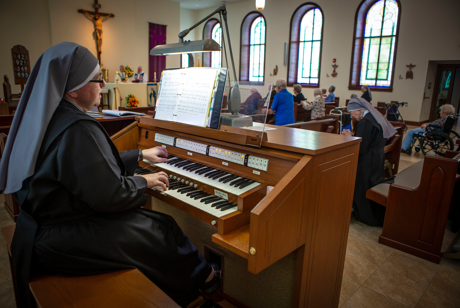 Sister Constance Veit, a Little Sister of the Poor, plays the organ during a March 25, 2019, Mass at the Jeanne Jugan Residence for senior care in Washington. Sister Constance is considered a spiritual mother by many of the residents, who said they will honor her on Mother’s Day.